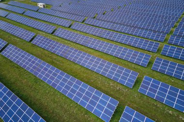 Temiz elektrik enerjisi üretmek için sıra sıra güneş fotovoltaik panelleri olan sürdürülebilir büyük elektrik santralinin havadan görünüşü. Sıfır emisyonlu yenilenebilir elektrik kavramı.