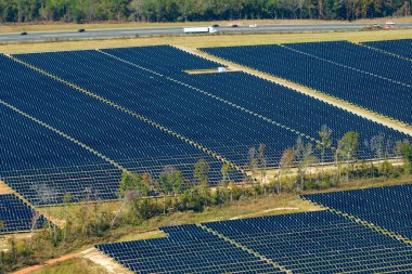 Temiz elektrik enerjisi üretmek için sıra sıra güneş fotovoltaik panelleri olan sürdürülebilir büyük elektrik santralinin havadan görünüşü. Sıfır emisyonlu yenilenebilir elektrik kavramı.
