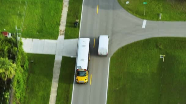 Widok Lotu Ptaka Amerykańskiego Żółtego Autobusu Szkolnego Jadącego Podmiejską Ulicę — Wideo stockowe