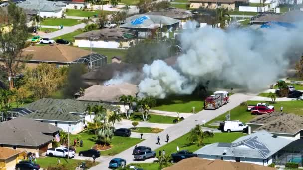 短絡後に火災や消防士の家の空中ビューは ハリケーンイアン風によって損傷した木製の屋根を点火する火花を引き起こした炎を消火します フロリダ郊外での住宅災害 — ストック動画