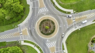 Aerial view of road roundabout intersection with moving cars traffic. Rural circular transportation crossroads.