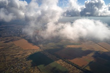 Dünya 'nın yüksek irtifasındaki hava manzarası yağmur fırtınasından önce oluşan kabarık kümülüs bulutlarıyla kaplıdır..