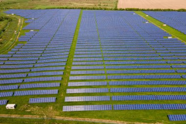 Temiz ekolojik elektrik enerjisi üretmek için birçok sıra güneş fotovoltaik paneli bulunan sürdürülebilir büyük elektrik santralinin havadan görünüşü. Sıfır emisyon kavramı ile yenilenebilir elektrik.