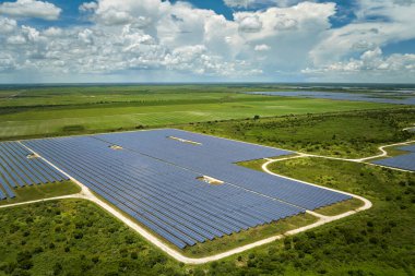 Temiz elektrik enerjisi üretmek için birçok sıra güneş fotovoltaik paneli bulunan sürdürülebilir büyük elektrik santralinin havadan görünüşü. Sıfır emisyon kavramı ile yenilenebilir elektrik.
