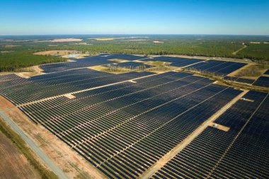 Temiz elektrik enerjisi üretmek için birçok sıra güneş fotovoltaik paneli bulunan sürdürülebilir büyük elektrik santralinin havadan görünüşü. Sıfır emisyon kavramı ile yenilenebilir elektrik.