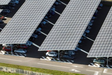 Güneş panellerinin hava görüntüsü park yerinin üzerine gölge çatısı olarak yerleştirilmiş ve temiz elektriğin etkin üretimi için park edilmiş arabalar var. Fotovoltaik teknoloji şehir altyapısına entegre edildi.