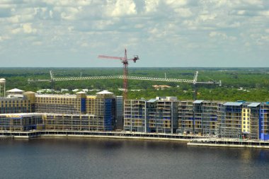 Tower lifting cranes at high residential apartment buildings construction site. Real estate development.