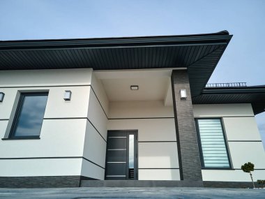 Ön verandası, şık kapısı, asfaltlı bahçesi ve pencereleri olan modern, modern konforlu bir ev..