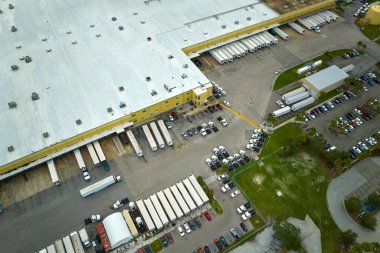 Büyük ticari nakliye merkezinin yüksek açılı görüntüsü. Daha fazla dağıtım için yükleme ve yükleme yapan bir sürü yük kamyonu var. Küresel ekonomi kavramı.