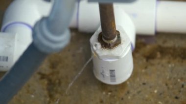 Amerikan evindeki su filtreleme sisteminin arızalı bağlantısından sızan plastik borular..