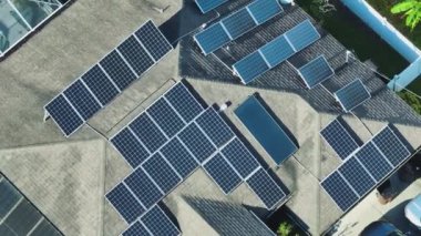 Kenar mahallelerde temiz ekolojik elektrik enerjisi üretmek için çatısı güneş fotovoltaik panellerle kaplı standart bir Amerikan yerleşim evi. Özerk konut kavramı.