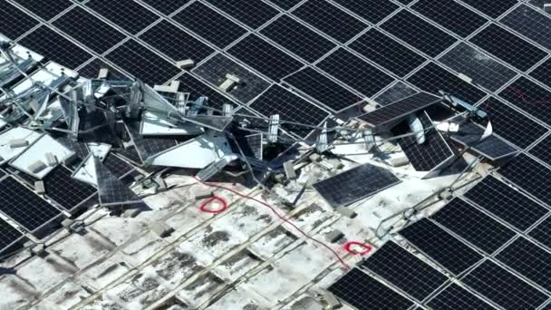 緑の生態系電力を生産するための産業用建物の屋根に取り付けハリケーンイアン太陽光発電パネルによって破壊されたのトップビュー フロリダ州での自然災害の結果 — ストック動画