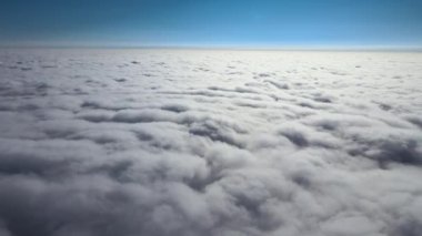 Dünya 'nın yüksek irtifasında, yağmur fırtınasından önce oluşan kabarık kümülüs bulutlarıyla kaplı uçak penceresinden hava görüntüsü.