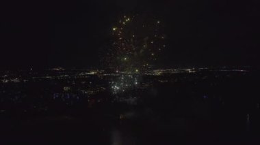 Aerial view of bright fireworks exploding with colorful lights over sea shore on US Independence day holiday.