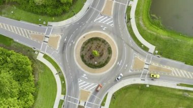 Aerial view of road roundabout intersection with moving cars traffic. Rural circular transportation crossroads.