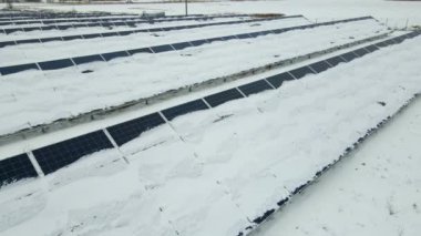 Kar, temiz elektrik enerjisi üretmek için birçok sıra güneş fotovoltaik paneliyle sürdürülebilir elektrik santralini kapladı. Kışın yenilenebilir elektriğin düşük etkisi.