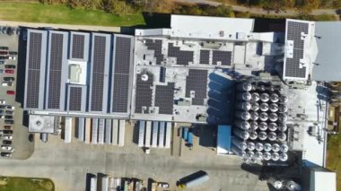 Sanayi binasının çatısına yeşil ekolojik elektrik üretmek için monte edilmiş mavi fotovoltaik panelli güneş enerjisi santralinin hava görüntüsü. Sürdürülebilir enerji konsepti üretimi.
