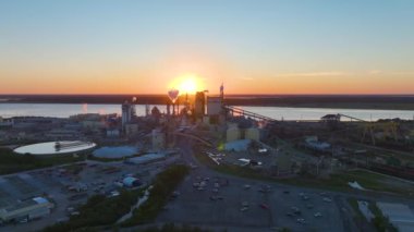 Ahşap işleme fabrikasının hava görüntüsü. Fabrika üretim alanındaki atmosferi kirleten bir duman bulutu. Gün batımında sanayi bölgesi.