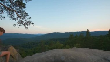 Hiker woman walking on mountain footpath enjoying evening nature. Lonely female traveler traversing wilderness trail. Healthy lifestyle concept.