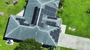 Kenar mahallelerde temiz ekolojik elektrik enerjisi üretmek için çatısı güneş fotovoltaik panellerle kaplı standart bir Amerikan yerleşim evi. Özerk konut kavramı.