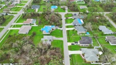 Asfalt kiremitlerin yerine konana kadar yağmur suyu sızıntılarına karşı koruyucu branda örtüleriyle kaplı çatı sızdıran evin üst görüntüsü. Florida 'daki Ian Kasırgası' nın yol açtığı çatı hasarı.