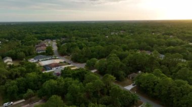 Florida 'daki yeşil palmiye ağaçları arasındaki banliyö özel evlerinin hava manzarası günbatımında sakin kırsal bölge.