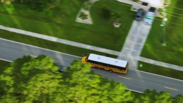 早朝に子供たちのための彼らのレッスンを拾うために郊外の通りに運転するアメリカの黄色のスクールバスの空中ビュー アメリカの公共交通機関 — ストック動画