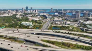 Jacksonville şehrinin hava manzarası. Yüksek ofis binaları ve hızlı araba ve kamyonlarla Amerikan otoyolu kavşağı. ABD ulaşım altyapısının üstünden görüntüle.