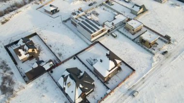 Soğuk kış mevsiminde kırsal kesimlerdeki çatıları karla kaplı özel evlerin hava manzarası..