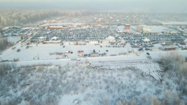 Açık pazar alanının hava manzarası. Satılık birçok araba park edilmiş ve insanlar kışın yürüyor..