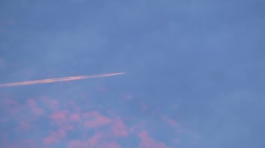 Mesafeli yolcu jet uçağı açık mavi gökyüzünde yüksek irtifada uçarken ardında beyaz duman izi bırakıyor. Hava taşımacılığı kavramı.
