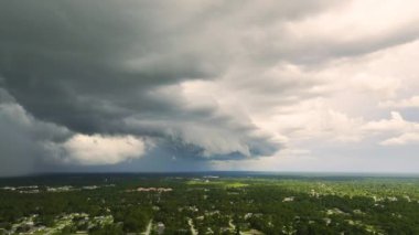 Landscape of dark ominous clouds forming on stormy sky before heavy thunderstorm over rural town area.