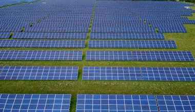 Temiz elektrik enerjisi üretmek için birçok sıra güneş fotovoltaik paneli bulunan sürdürülebilir büyük elektrik santralinin havadan görünüşü. Sıfır emisyon kavramı ile yenilenebilir elektrik.