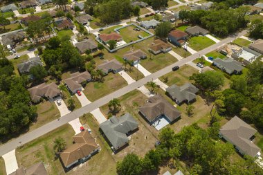 Florida 'nın sakin yerleşim bölgesinde yeşil palmiye ağaçları arasında özel evleri olan küçük bir Amerikan banliyö manzarası..