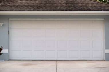 Geniş garaj, çift kapı ve modern Amerikan evinin beton yolu..