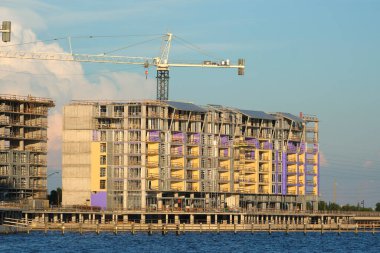 Tower cranes and frame structure of high residential apartment buildings at construction site. Real estate development.