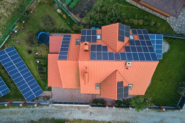 Residential house with rooftop covered with solar photovoltaic panels for producing of clean ecological electrical energy in suburban rural area. Concept of autonomous home.