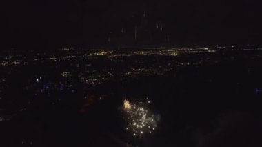 Aerial view of bright fireworks exploding with colorful lights over sea shore on US Independence day holiday.