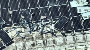 Yeşil ekolojik elektrik üretmek için endüstriyel yapı çatısına monte edilen rüzgar fotovoltaik güneş panellerinden hasar gören hava görüntüsü. Doğal afetin sonuçları..