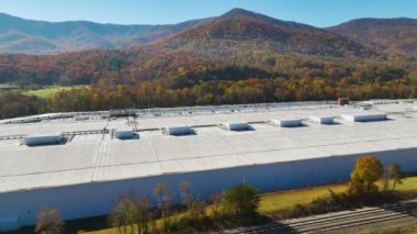 Büyük ticari dağıtım merkezinin hava görüntüsü. Daha fazla sevkiyat için birçok kamyon indiriyor ve indiriyor. Küresel ekonomi kavramı.