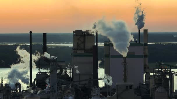 工場の製造現場で大気汚染の生産プロセスからのスモケスタックを持つ大規模工場の空中ビュー 日没時の工業用地 — ストック動画