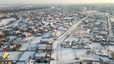 Soğuk kış mevsiminde kırsal kesimlerdeki çatıları karla kaplı özel evlerin hava manzarası..