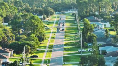 Küçük bir kasabada sokak trafiğinin hava görüntüsü. Florida 'da sakin yerleşim bölgesinde yeşil palmiye ağaçları arasında özel evleri olan Amerikan banliyö manzarası.