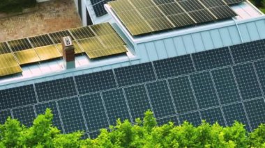 Temiz ekolojik elektrik enerjisi üretmek için mavi güneş fotovoltaik panelleri olan tipik Amerikan binasının çatısı. Emeklilik geliri kavramı için yenilenebilir elektriğe yatırım.