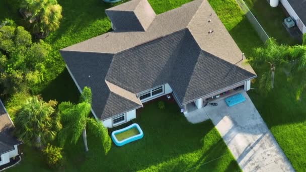 屋根の上にアスファルトの帯状疱疹と庭の緑の芝生で覆われた典型的な現代アメリカの民家の空中ビュー — ストック動画