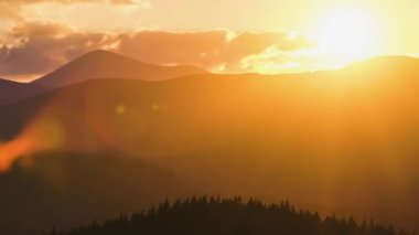 Güzel bir akşam panoramik manzarası. Gün batımında uzak dağ tepeleri üzerinde parlak batan güneş..