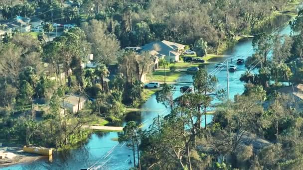 移動する車でアメリカの通りを浸水し フロリダの住宅地の水の家に囲まれています ハリケーンイアンの自然災害の結果 — ストック動画