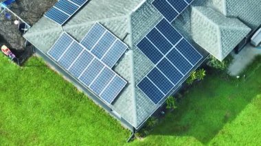 Temiz ekolojik elektrik enerjisi üretmek için mavi güneş fotovoltaik panelleri olan normal Amerikan ev çatısı. Emeklilik geliri için yenilenebilir elektriğe yatırım.