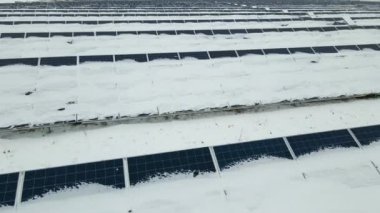 Kar, temiz elektrik enerjisi üretmek için birçok sıra güneş fotovoltaik paneliyle sürdürülebilir elektrik santralini kapladı. Kışın yenilenebilir elektriğin düşük etkisi.