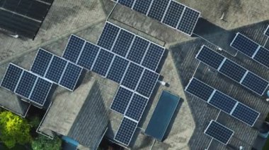 Aerial view of typical american building roof with rows of blue solar photovoltaic panels for producing clean ecological electric energy. Renewable electricity with zero emission concept.